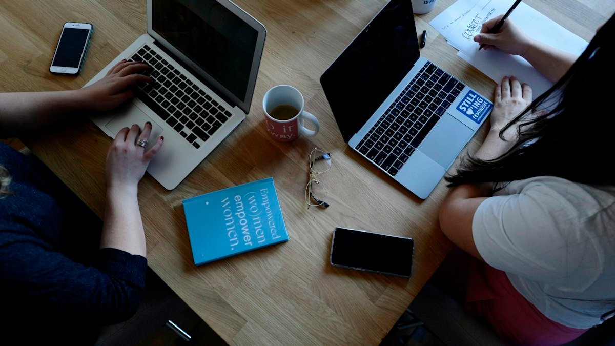 Two people working on laptops – website, app and SEO pricing
